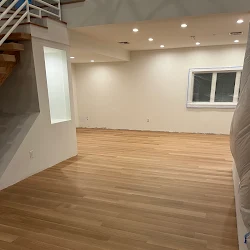 Empty commercial space with wooden flooring and white walls