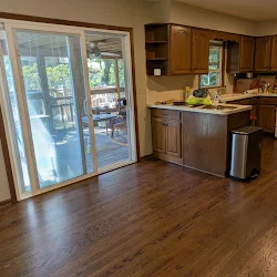 Modern kitchen with wood cabinets, stainless steel appliances, and sliding glass doors opening to patio
