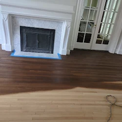 Living room with dark hardwood floors, fireplace with blue base, and glass-paned cabinet doors
