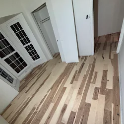 Three white air conditioning units displayed on wooden plank flooring